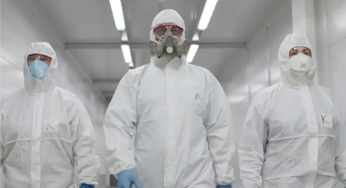 Three employees in hazmat suits walking down an apartment hallway, ready to perform a safe and efficient junk removal operation.